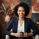 A diverse, happy customer smiling in a professional portrait headshot for a customer testimonial.