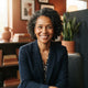 A friendly, smiling woman looking directly at the camera, conveying trust and satisfaction.